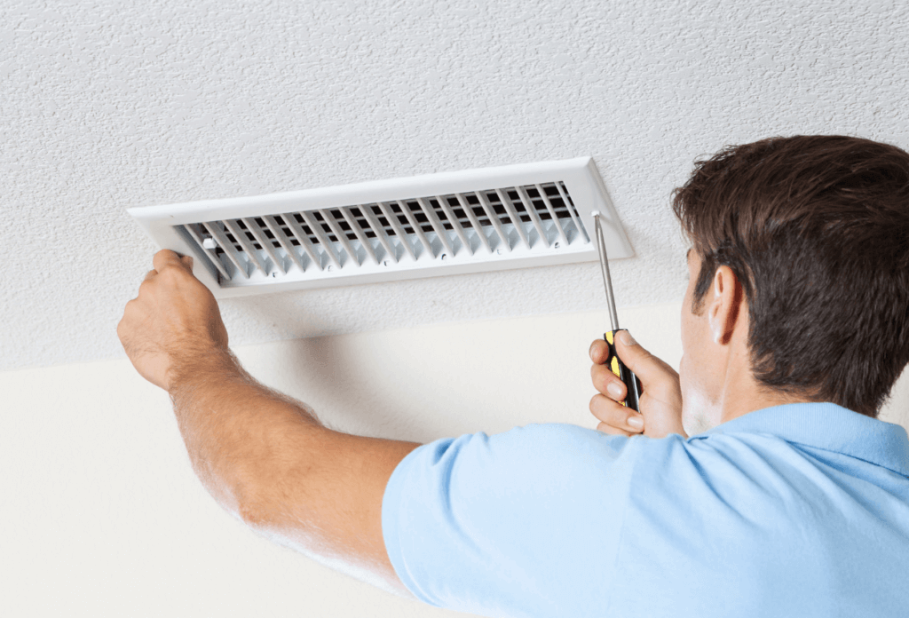 A picture of an air conditioning expert doing an A/C tune-up.